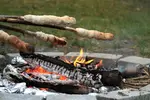 A traditional campfire bread on a stick recipe, plus outdoor cooking techniques for making delicious griddle cakes, pancakes, and muffins over an open fire.