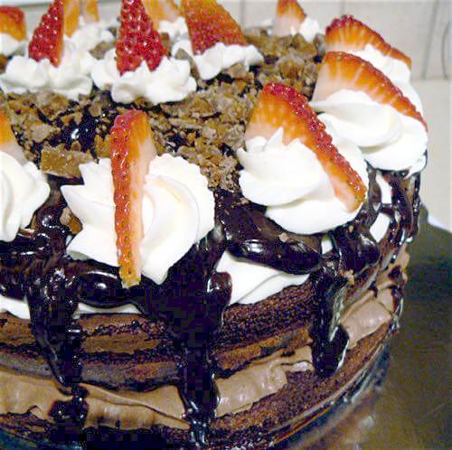 Here's an easy chocolate ganache mousse cake recipe for a decadent homemade dessert. Chocolate cake with mousse filling, topped with ganache and whipped cream.