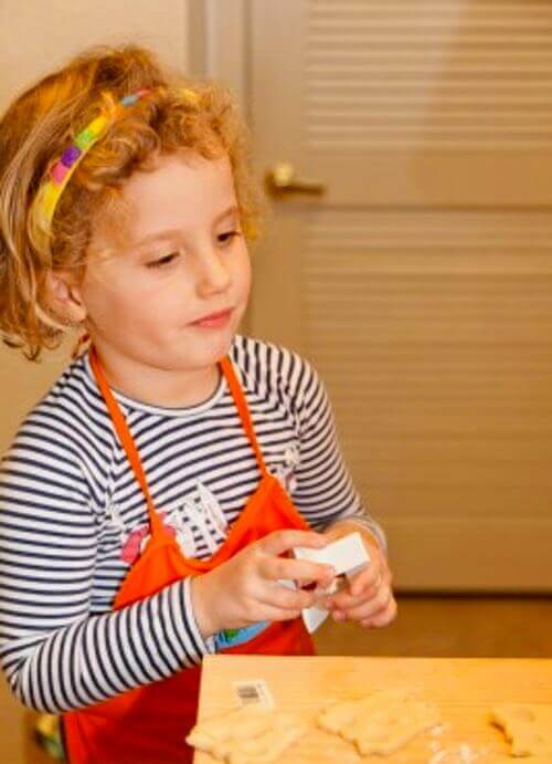 Little Girl Cutting Out Homemade Cookies