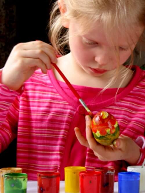 Girl Having Fun Coloring Easter Eggs