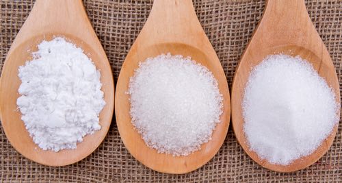 Wooden Spoons Holding Three Types of White Sugar